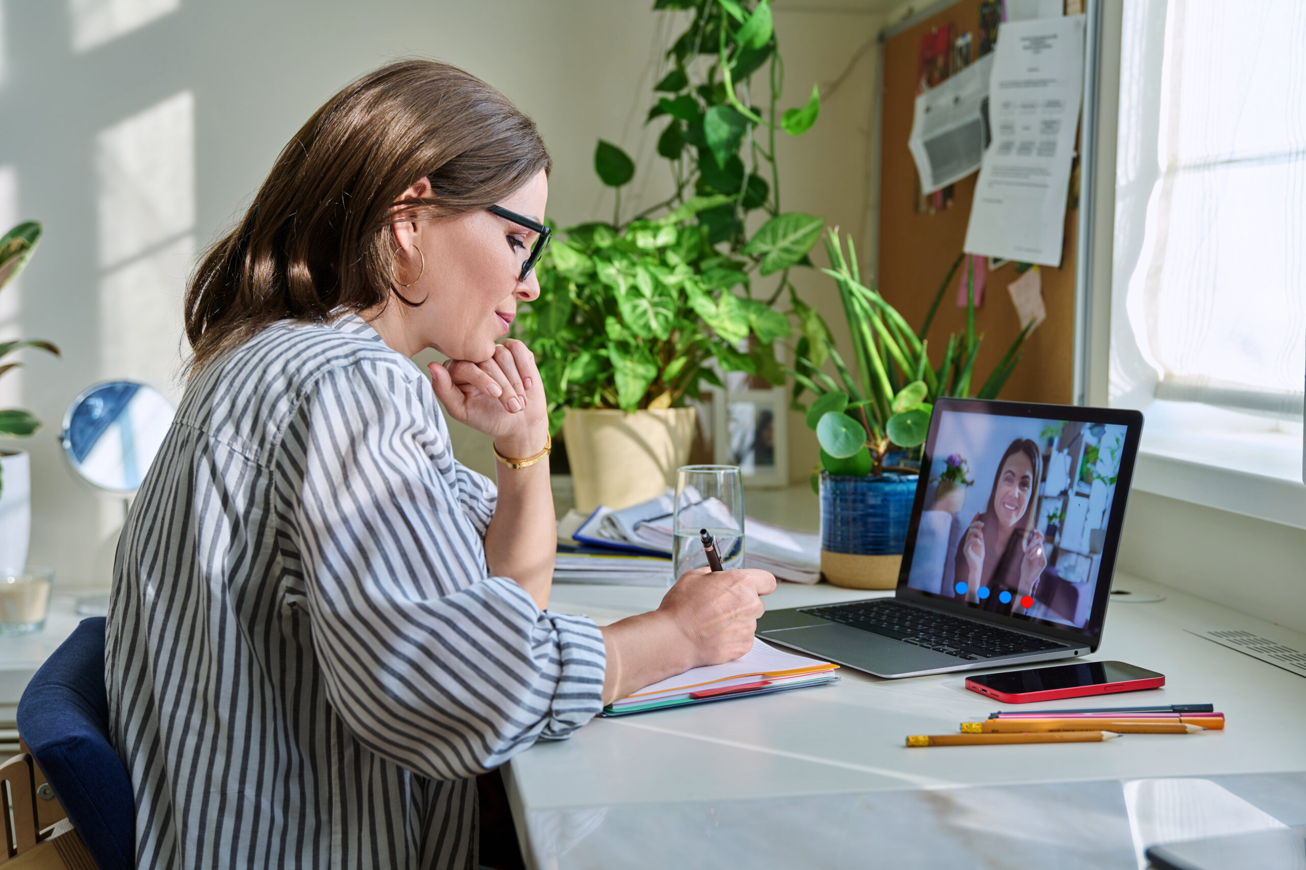 Middle aged woman having video conference on laptop with young woman